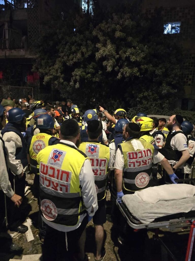 מתנדבי הצלה מעניקים טיפול רפואי בזירת נפילת טיל